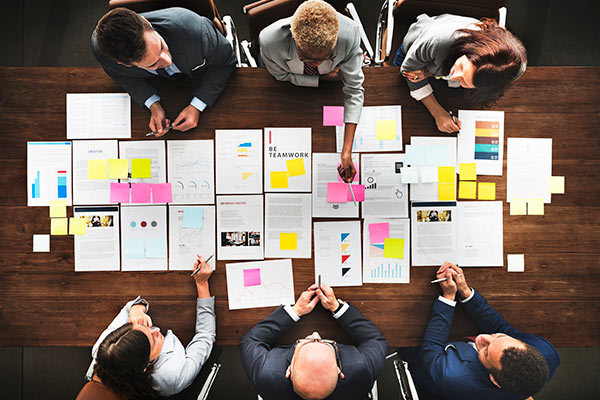 8 people sat around a conference room table